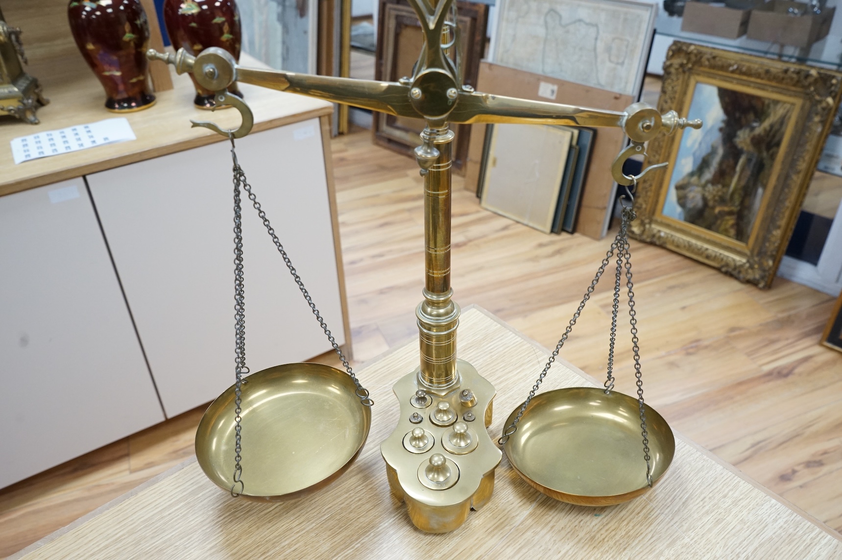 A pair of brass beam scales with decorative bull's head finial and weights, 56cm high